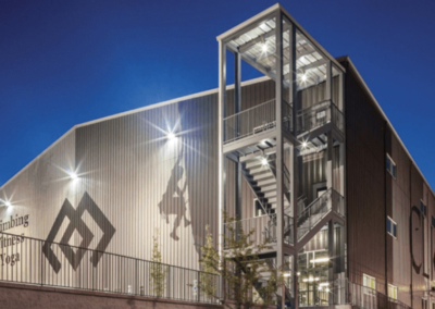 A modern building illuminated at night, showcasing its sleek architecture against a dark sky